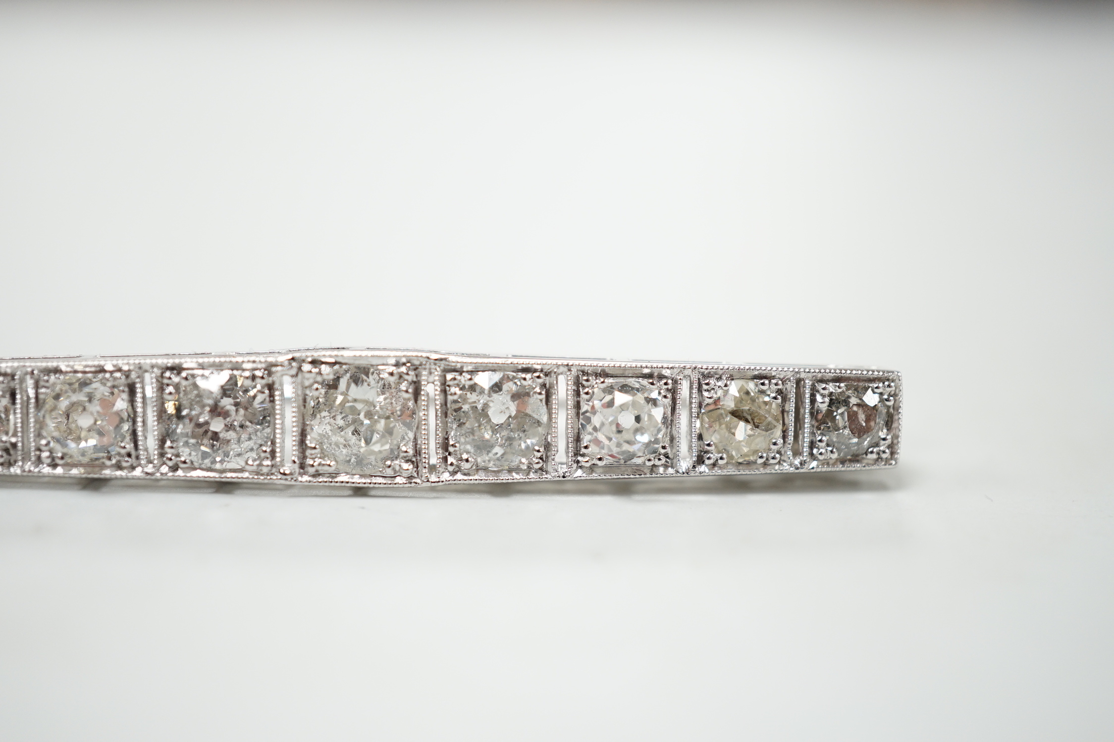 A 1920's/1930's white metal and graduated nine stone diamond set bar brooch, 48mm, gross weight 4.6 grams.